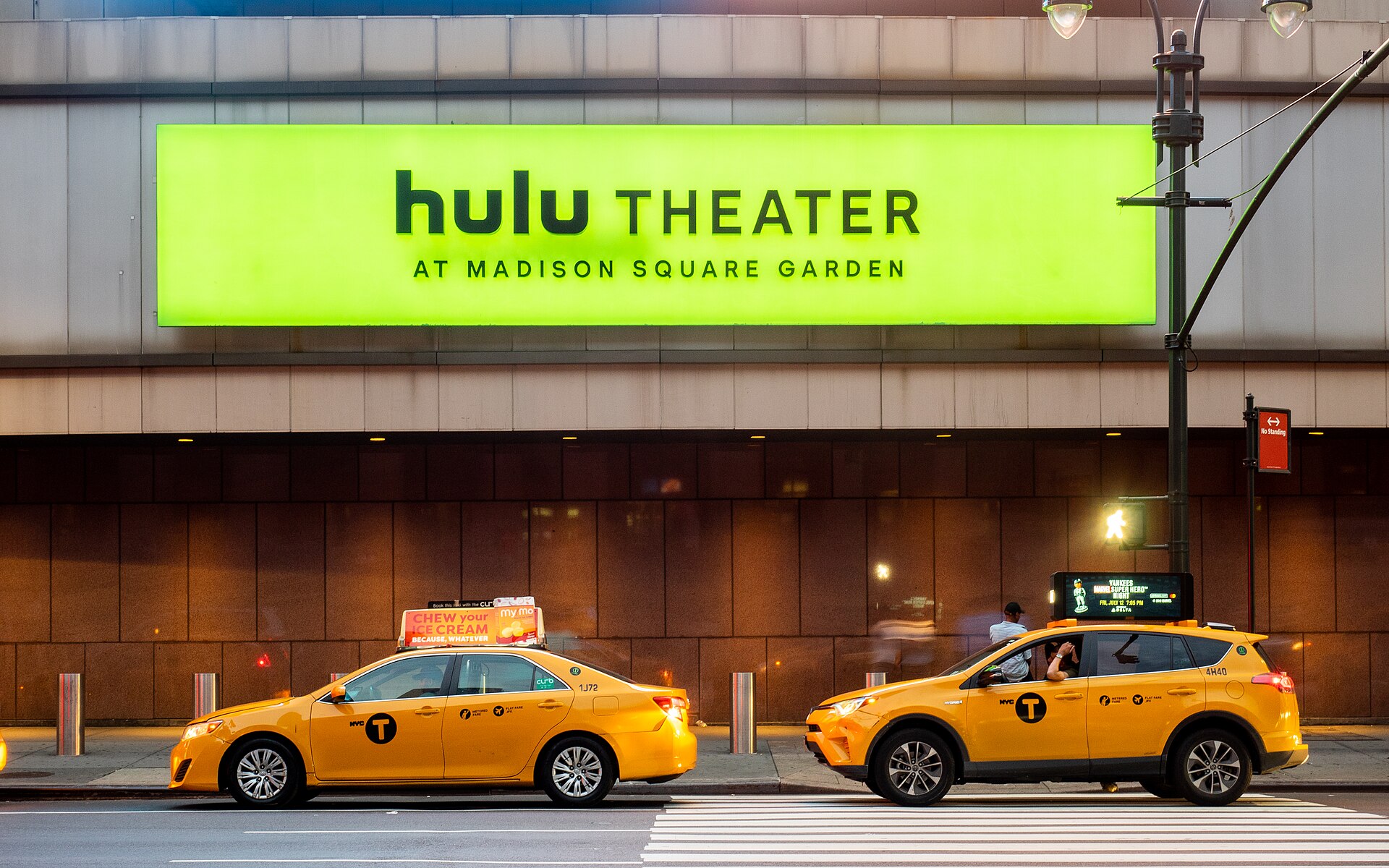 Letrero iluminado del Hulu Theater en Madison Square Garden sobre taxis de Nueva York