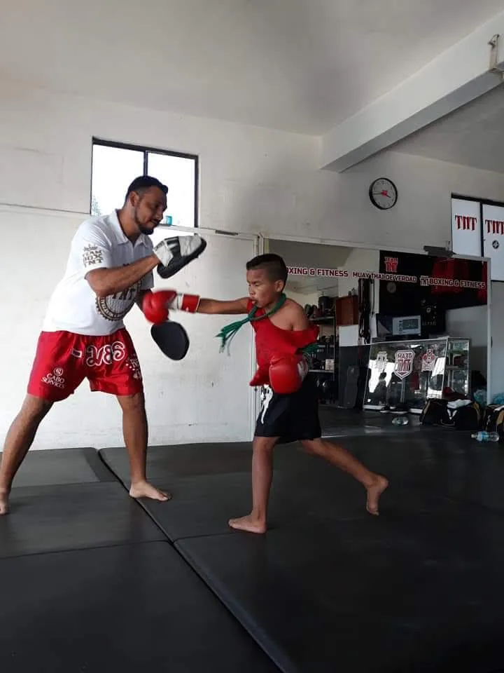 Un joven practicando golpes con su entrenador en TNT Boxing Fitness