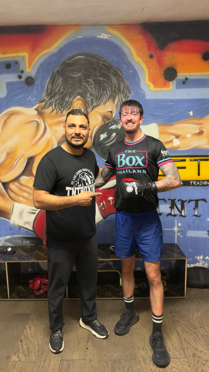 Dos personas posan en TNT Boxing Fitness; una lleva guantes de boxeo